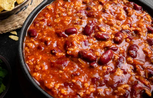 Bowl of chili in a cast iron pan, game day recipe inspired by family traditions, shared through Little Bird Productions farm-to-table storytelling blog.
